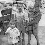 BAMBINI gruppo di quattro in posa a Cortile Cascino: il più grande tiene in braccio la più piccola. Fotografia di Ando Gilardi da ampio servizio, Palermo 1957.